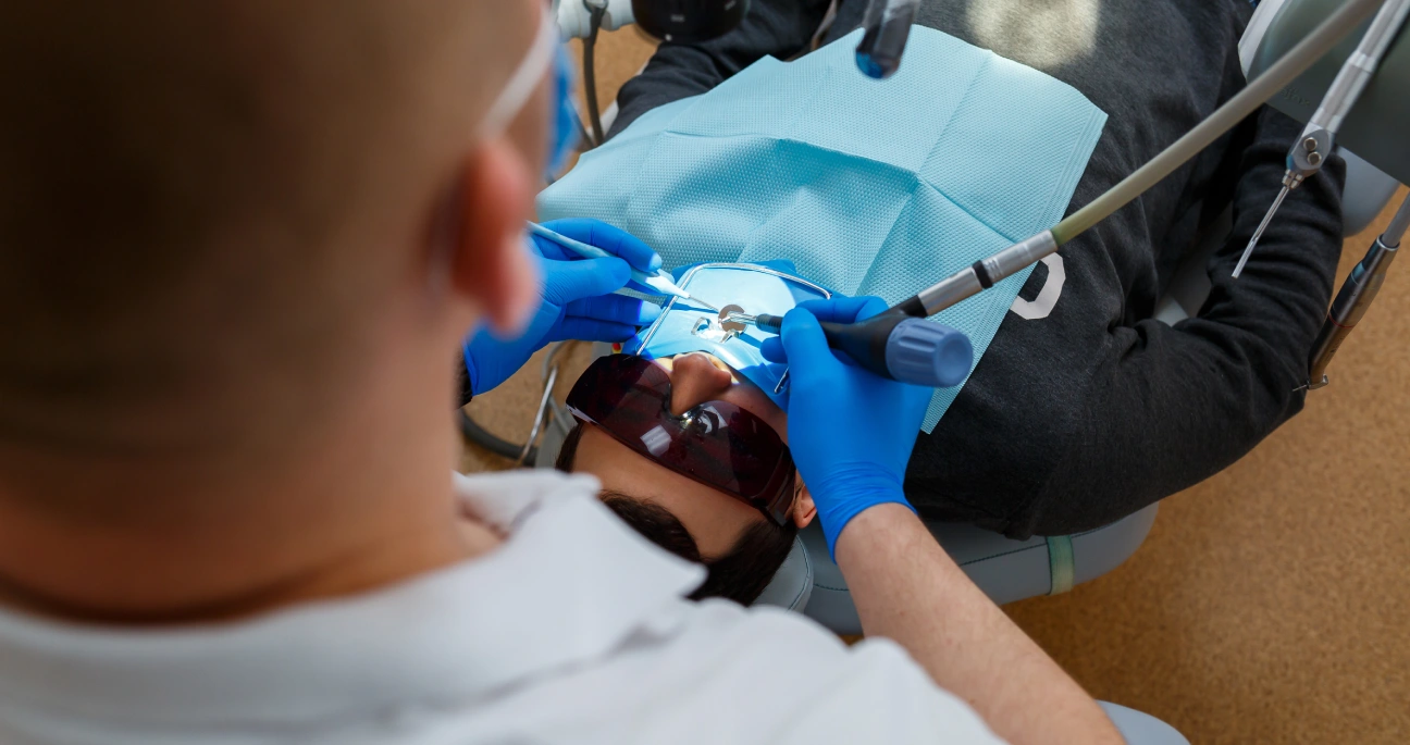 dentista realizando cirurgia de recobrimento radicular.